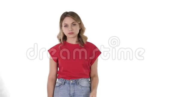 年轻的女人一头金发穿着红色T恤看着白色背景上毫无感情的镜头视频的预览图