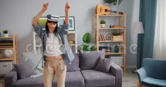 快乐的嬉皮士在家里玩虚拟现实眼镜放松的快乐舞蹈视频的预览图