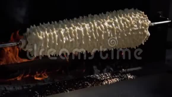 在外面的明火上烹饪传统的分层蛋糕Sakotis鲍姆库臣是甜的金黄色的树饼视频的预览图