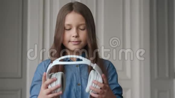 快乐的孩子听音乐美丽的微笑女孩戴耳机视频的预览图