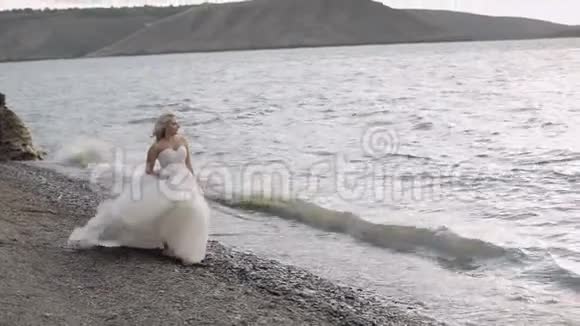 美丽可爱的新娘靠近大海漂亮又整洁的女人近距离射击金发美女婚礼日视频的预览图