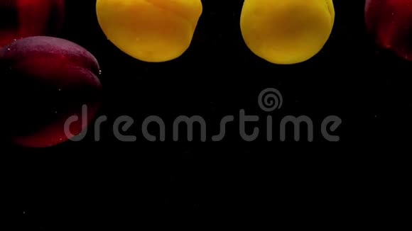 桃子和杏子在黑色背景的透明水中视频的预览图