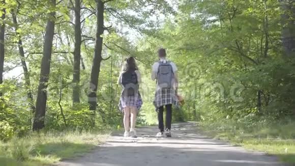 肖像男和年轻可爱的女孩在森林里散步一对旅行者带着背包在户外休闲夫妇视频的预览图