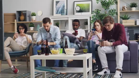 男人和女人使用智能手机然后一起在家里看电视新闻视频的预览图
