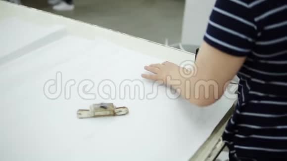 裁缝时装设计师用特殊的刀具作为磨床用白色材料加工视频的预览图