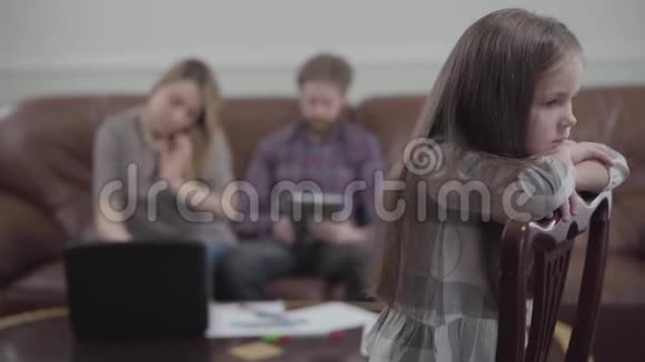年轻女人在她的笔记本电脑上打字胡子男在后台工作他的平板电脑的模糊形象小小的悲伤视频的预览图