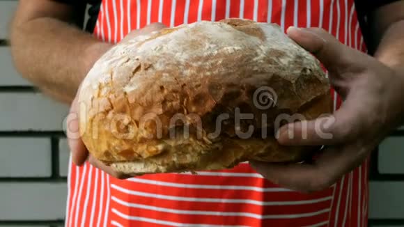 白种人的厨师手拿着一大块开胃菜的面包视频的预览图