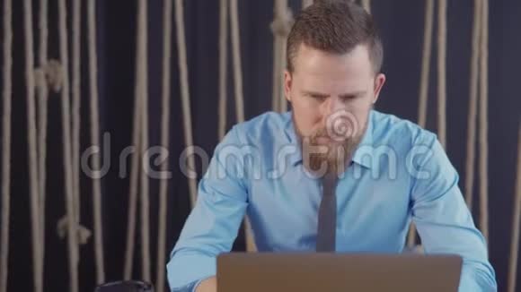 男性办公室工作人员正集中注意笔记本电脑的展示向后倾斜视频的预览图