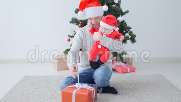 圣诞节的概念可爱的孩子在爸爸手圣诞老人的帽子视频的预览图