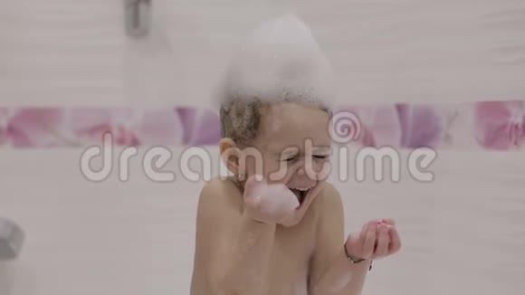 漂亮的三岁女孩洗澡湿发与浴沫可爱的金发孩子棕色的眼睛可爱的女孩微笑漂亮的李视频的预览图