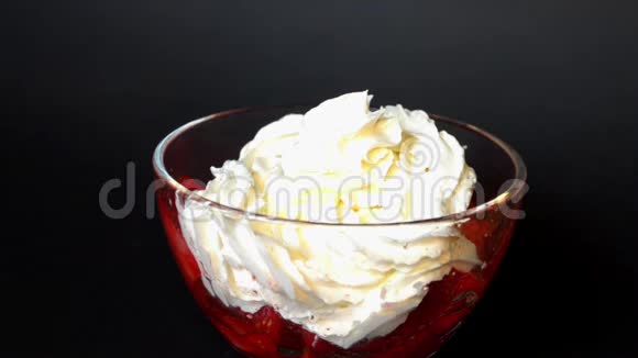 在黑色背景的玻璃碗中加入奶油的草莓与巧克力一起倒入视频的预览图