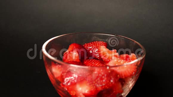 一块草莓放在黑色的玻璃碗里其中一个用叉子刺视频的预览图