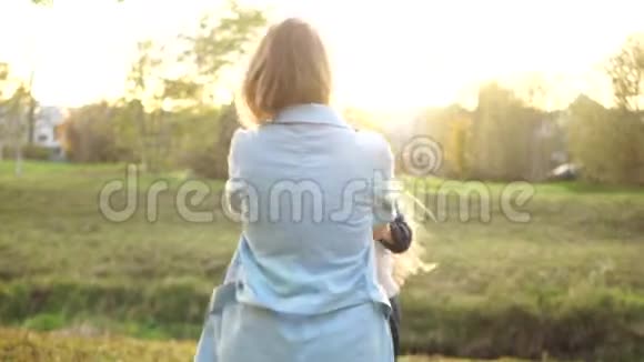 母女俩在秋天公园玩得很开心一个女孩和她年轻的母亲牵着手旋转母亲节视频的预览图