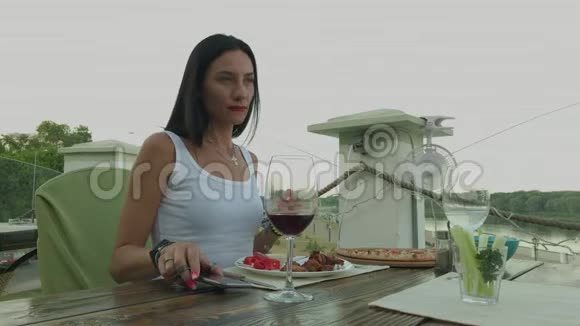 美女从餐厅的桌子上拿起电话视频的预览图