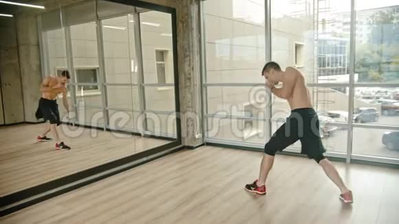 一个运动员站在工作室里在镜子前训练拳击视频的预览图