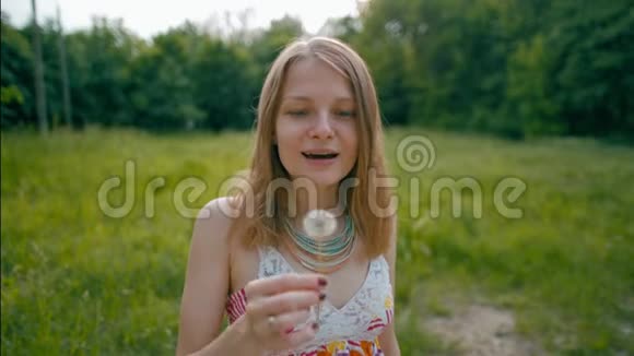 女子吹蒲公英中镜头及即将到来的夏天与大自然视频的预览图