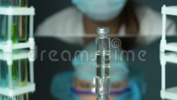 实验室工作人员看着疫苗样品站在桌子上药物开发视频的预览图