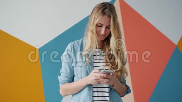 快乐女孩使用智能手机触摸屏幕在室内享受社交媒体视频的预览图