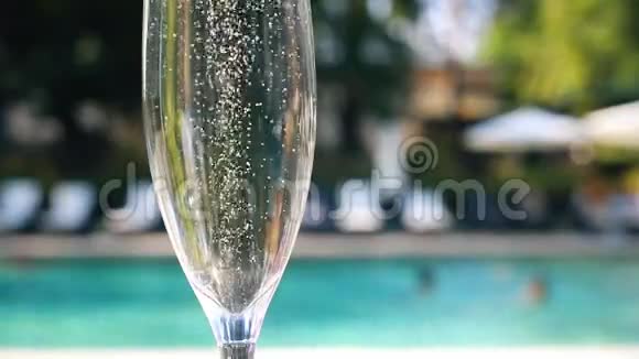 度假期间在豪华度假酒店的泳池边为客人提供近景的白色香槟或普罗塞克玻璃提供起泡葡萄酒视频的预览图