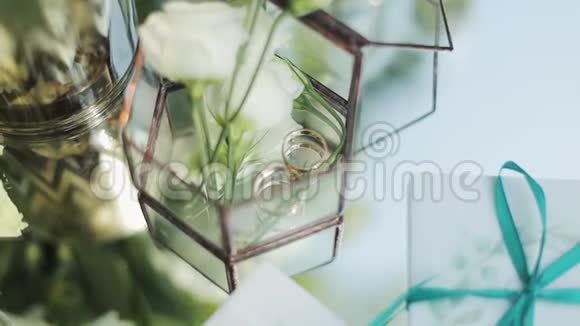 在花的背景上特写两个结婚戒指很漂亮的婚礼装饰结婚戒指婚礼黄金戒指视频的预览图