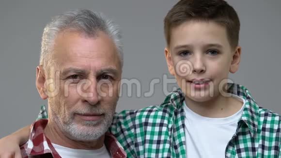 可爱的男孩和祖父看着相机家庭关系在一起视频的预览图