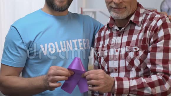 两个男人拿着紫罗兰色的丝带志愿支持老人老年痴呆症视频的预览图