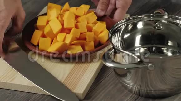 奶油南瓜汤烹饪健康食品厨师把一小块南瓜放在一张钢制的发亮的平底锅里放在一张木桌上快关门视频的预览图