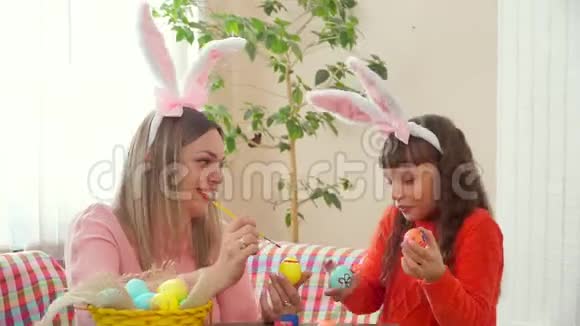 母亲和女儿准备过一个快乐的复活节画鸡蛋我女儿保存着像眼睛一样画的鸡蛋视频的预览图