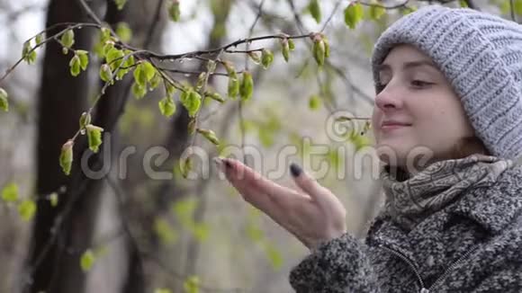 女孩用手指欣赏和触摸盛开的叶子潮湿的雪视频的预览图