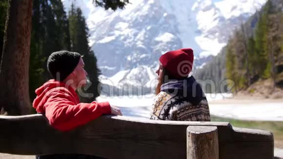 年轻夫妇在旅行坐在长凳上说话视频的预览图