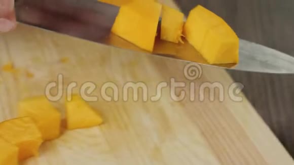 奶油南瓜汤烹饪健康食品厨师把南瓜片放在一张棕色盘子里的木桌上快关门4K视频的预览图