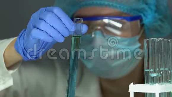 实验室助理检查试管中蓝色液体将测试结果插入片剂视频的预览图