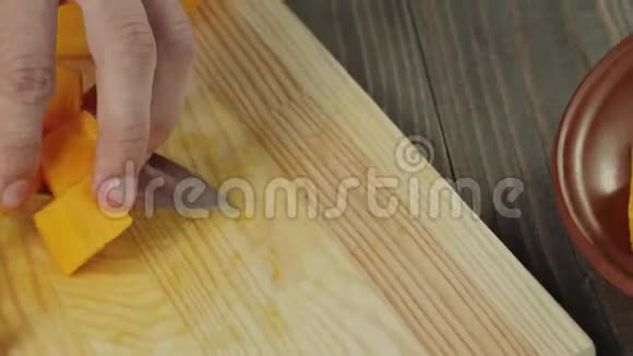 奶油南瓜汤烹饪健康食品厨师把南瓜片放在一张棕色盘子里的木桌上快关门视频的预览图