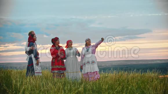 人们穿着传统的民间服装站在田野上自拍视频的预览图
