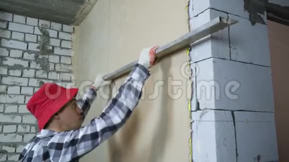 建筑工人用施工尺在内墙上刮平灰泥视频的预览图