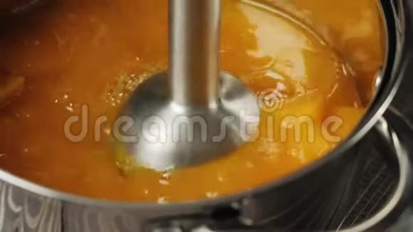 奶油南瓜汤烹饪一小块南瓜正在用搅拌机在一个钢亮的平底锅里研磨快关门4K视频的预览图