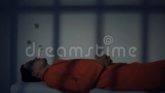 白种人囚犯躺在木板床上思考终身监禁视频的预览图