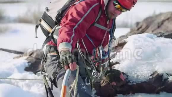 爬上山缝靠在他的手和一个冰镐上他的肩膀上有个背包视频的预览图