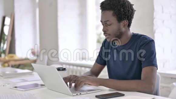 非洲年轻人喝咖啡和做手提电脑视频的预览图