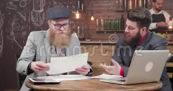 年轻的金发商人留着时髦的胡子和他的生意伙伴在会上视频的预览图