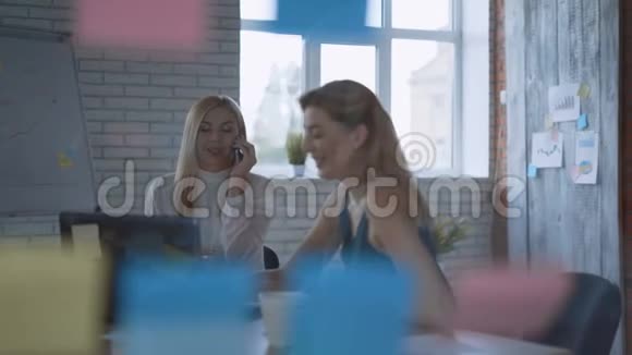 两个严肃的女人在现代办公室谈判电话会议视频的预览图