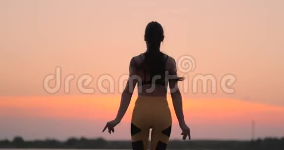 快乐健身女士在户外海边做跳千斤顶或跳星运动复制空间在海滩上工作的女孩视频的预览图