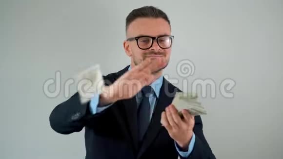 穿着正式服装的人把一美元的钞票撒在身上赚钱视频的预览图