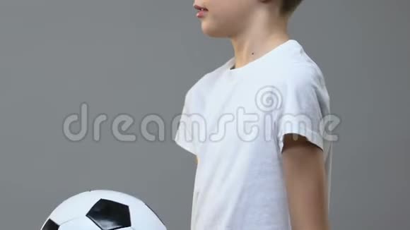 可爱的男孩在灰色背景下玩足球运动娱乐视频的预览图
