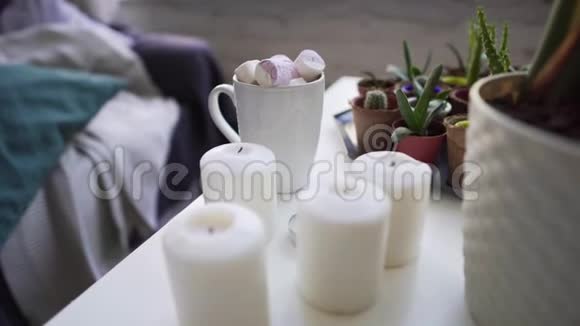 在寒假里放松一杯热巧克力白色桌子上放着棉花糖冷的家里放着蜡烛视频的预览图