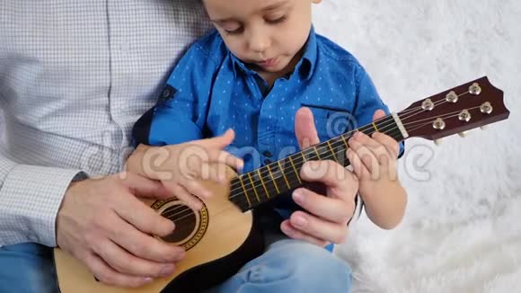 爸爸和儿子一起弹吉他把爸爸和儿子的手举起来视频的预览图