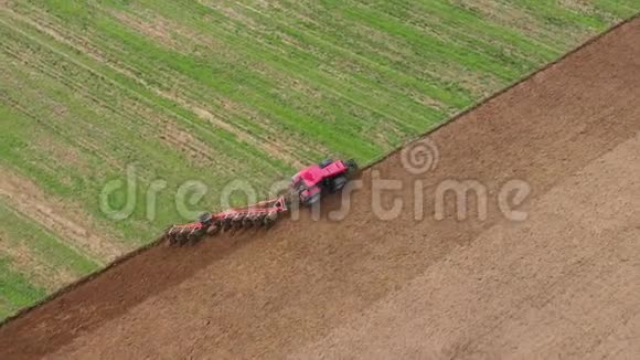红色拖拉机犁绿色农业田增加收获空中景观视频的预览图