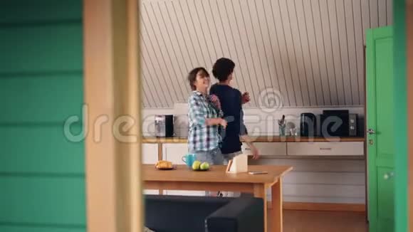 可爱的一对快乐的男人和他漂亮的女朋友在漂亮的房子里的厨房里玩得很开心放松的跳舞和跳舞视频的预览图