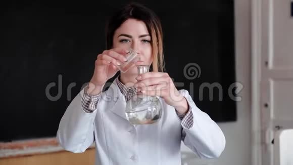 女科学家在医学实验室检查不同化学物质的烧瓶的画像视频的预览图