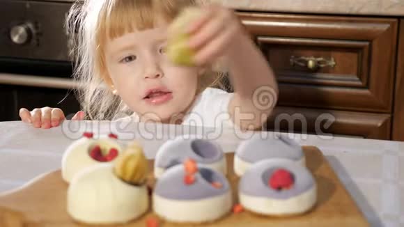 小可爱的女孩正在用覆盆子装饰小蛋糕视频的预览图